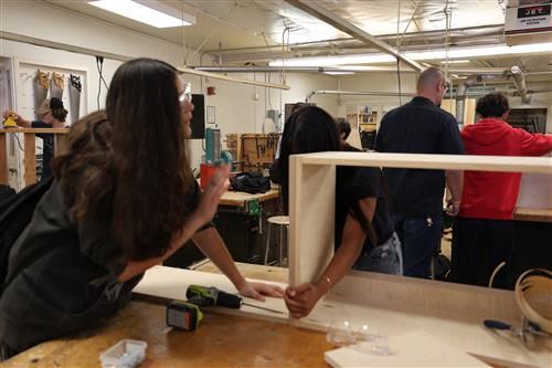Students working on cabinet building and sinking skews.