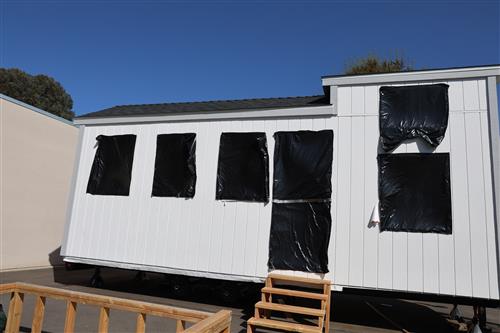 Tiny home with window covered to protect the inside from the weather.