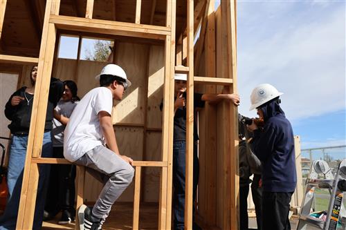 Students working hard to prepare the home for siding.