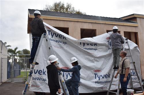 Students helping to install the moister barrier.