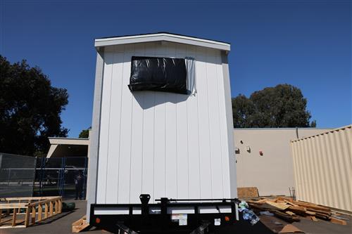 Tiny home with window covered to protect the inside from the weather.