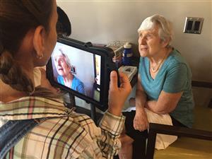 Student filming a senior resident.