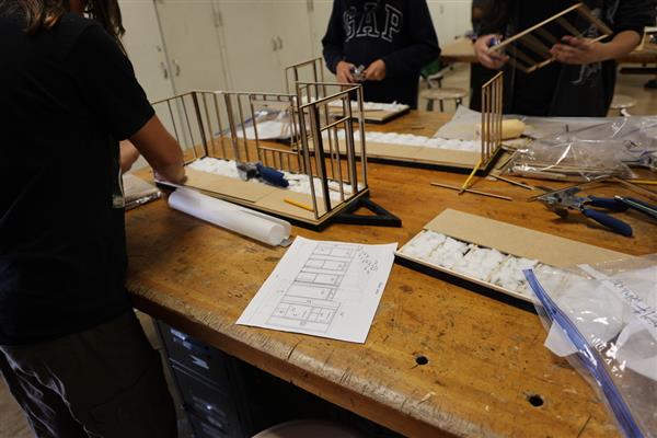 Wood shop students working on tiny home model.