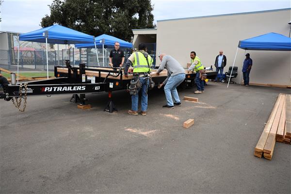 Wood shop students working on the construction site trying to complete the framing of the floor before the rain hits.