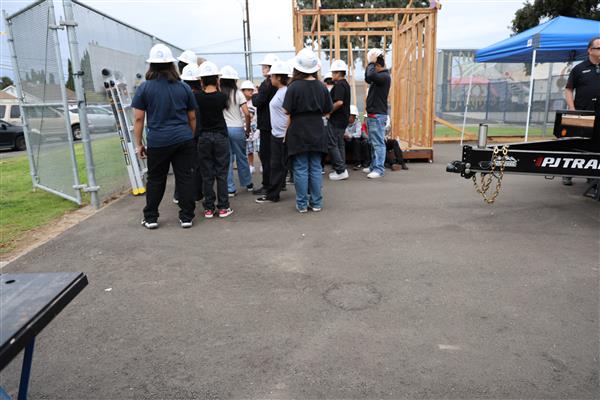 Wood shop students working on the construction site trying to complete the framing of the floor before the rain hits.