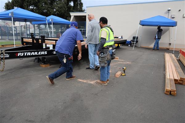 Wood shop students working on the construction site trying to complete the framing of the floor before the rain hits.