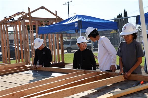 Wood shop students working on laying the floor boards.