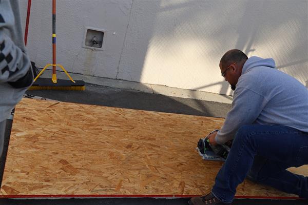 Mr. Vidales showing the students how to use the circular saw to cut the subfloor.