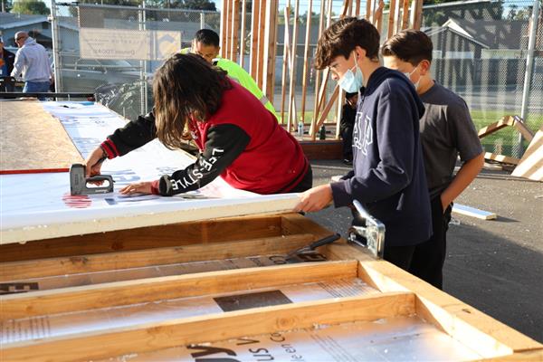 Wood shop students working on adding instillation to the floor.