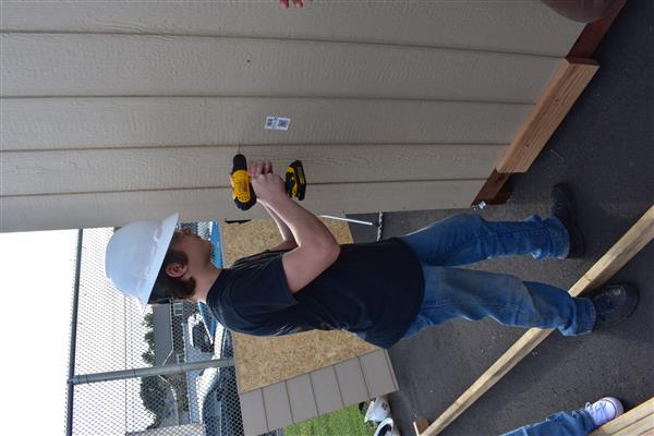 Practicing installing siding on the shed.
