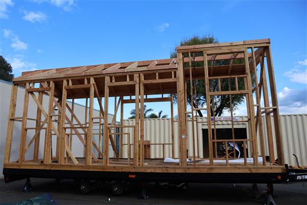 Tiny home frame and roof rafters complete, now working on putting plywood up for the roof.