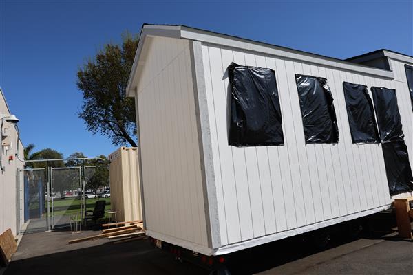 Siding has been installed and windows protected while students work inside on electrical. 