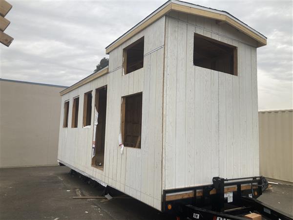 Siding has been installed and windows protected while students work inside on electrical. 