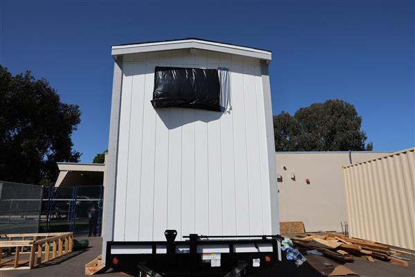 Siding has been installed and windows protected while students work inside on electrical. 