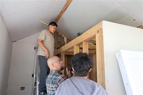 Mr. Vidales and students discussing what needs to be done in the bathroom.