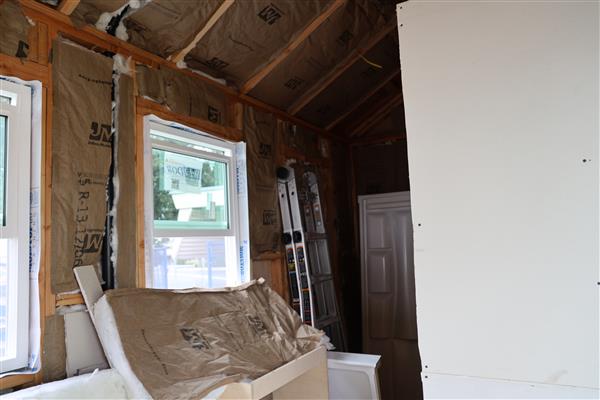 Students working on insulation and preparing for drywall.