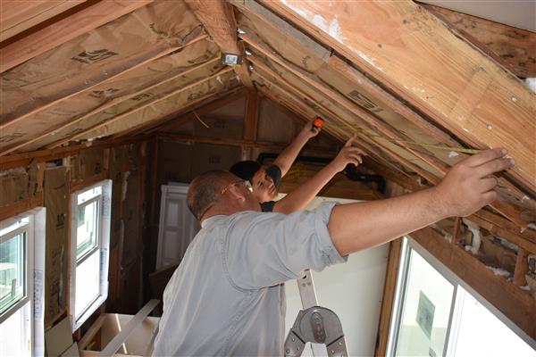 Mr. Vidales and student measuring for drywall.