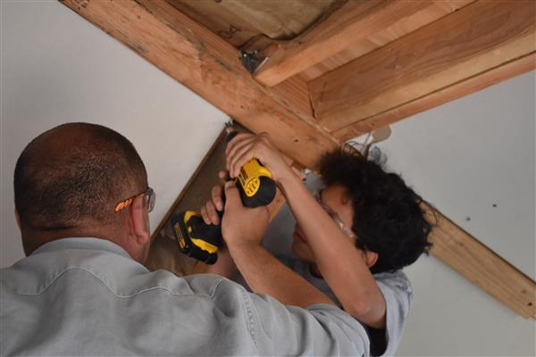 Installing drywall on the ceiling.