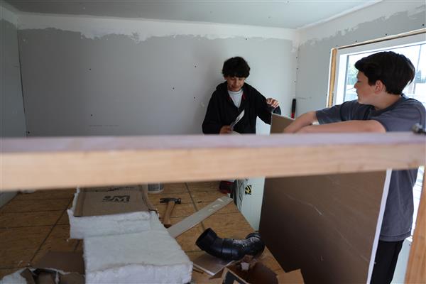 Students working on mudding the dry wall.