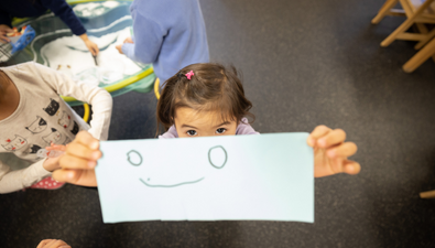  Preschool student holding up her drawing